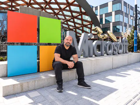 M. Mustafa Bolat, Microsoft kampüsünde renkli Microsoft logosunun ve Microsoft yazısının önünde otururken
